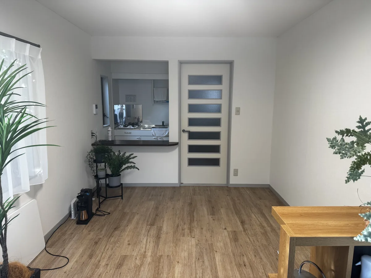 A real room photographed before an AI redesign, showing the empty floor space and wall a sofa would occupy